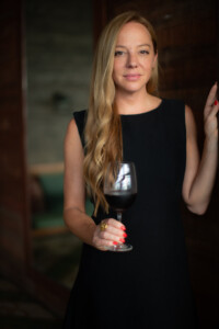 Porträttbild på vinentreprenören Cecilia Oldne med vinglas i handen
