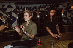 Porträttbild på Pia Dahlbom i en bar med en annan person i bakgrunden