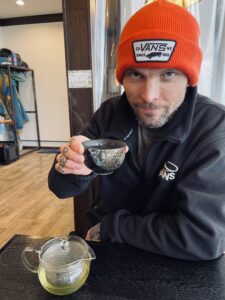Porträttbild på Snowboardproffset PJ Gustafsson med japanskt grönt te och orange vansmössa