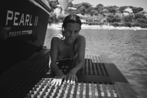 Svartvit porträttbild på Samanda Ekman i vattner bakom en båt