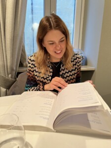 Porträttbild på Ulrika Ferlin som läser i en massiv vinlista.