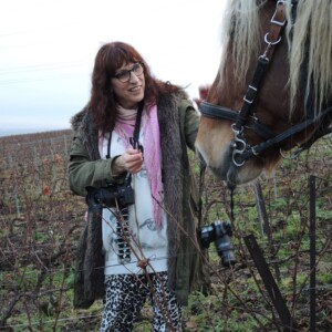 Porträttbild på Nadja Karlsson med en häst i en vingård