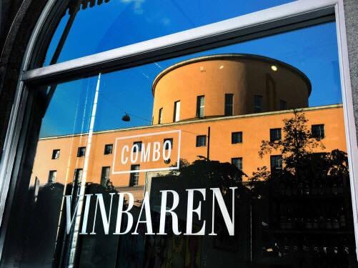 Stadsbiblioteket speglas i fönstret på Combo vinbaren